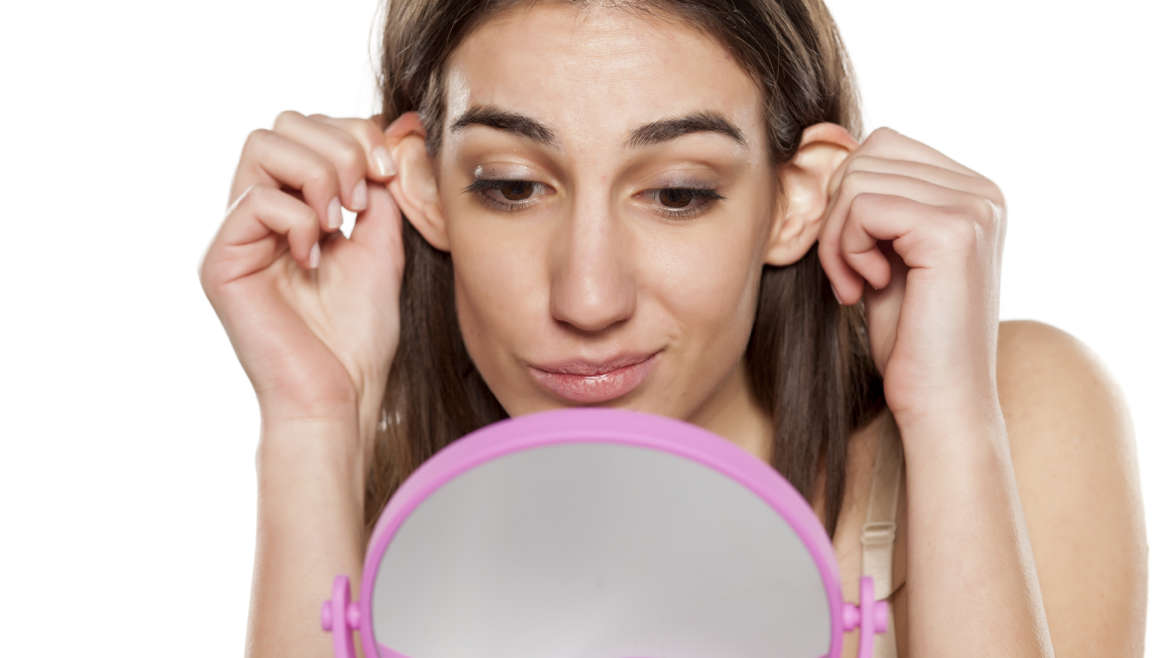 beautiful-young-woman-looks-at-her-ears-in-front-of-the-mirror