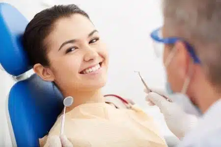 21344599-image-of-smiling-patient-looking-at-camera-at-the-dentistu2019s